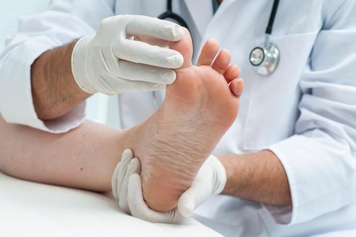 A doctor assessing the foot of a patient